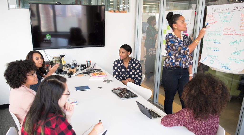 a group of young black women in a meeting in an office setting